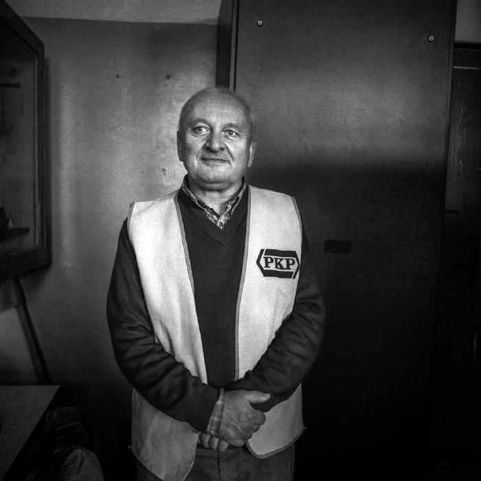 Zwart-witportret van een man in een vest met PKP-logo